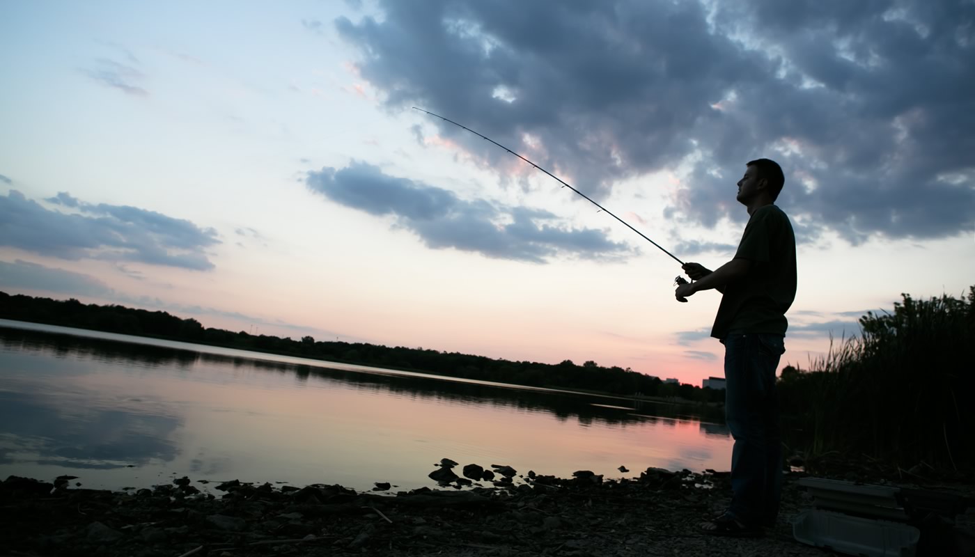 person fishing on Busse Reservoir just before sunset