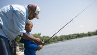 an adult and child fishing at Wampum Lake during Kids Fest event