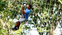 a person climbing a net on the Go Ape Tree Top Adventure Course in Bemis Woods