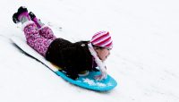 a child sledding at Caldwell Woods
