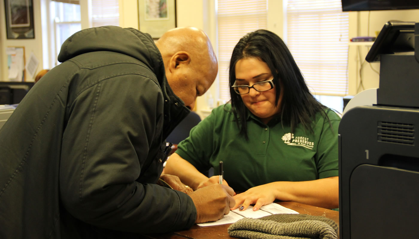 a Forest Preserves employee helps with a permit application