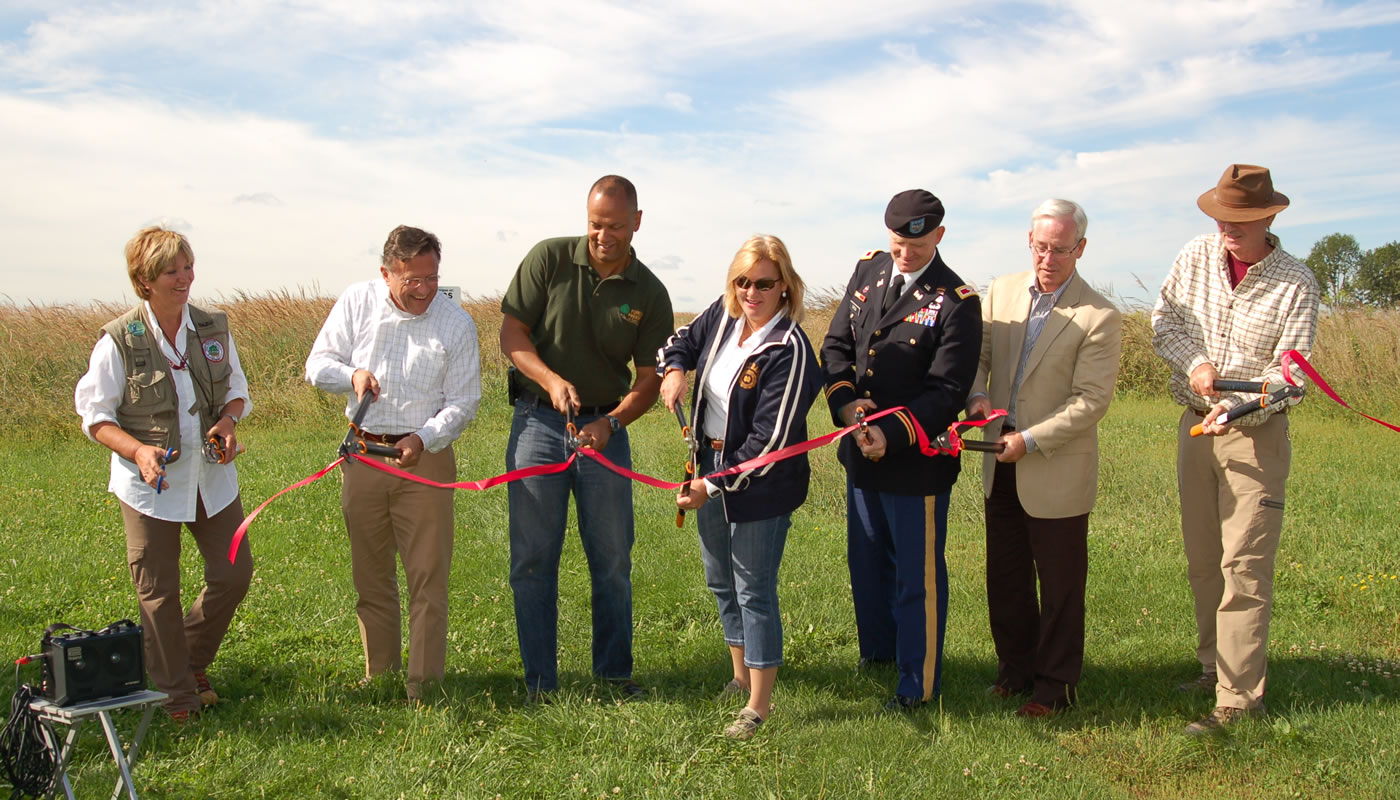 Ribbon cutting at Orland Grassland - Left to right: Pat Hayes (Orland Grassland Volunteers), Gerald Adelmann (Openlands), Arnold Randall (FPCC), Forest Preserves Commissioner Elizabeth Gorman, Col. Christopher Drew (Army Corps), Mayor Dan McLaughlin (Village of Orland Park), Stephen Packard (founding director of Audubon Chicago Region)