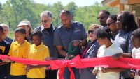 People cutting a ribbon at the opening of Camp Shabbona Woods.