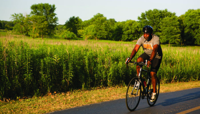 a person riding a bike on the paved trail at Busse Woods