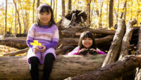 two children playing on a log at River Trail Nature Center