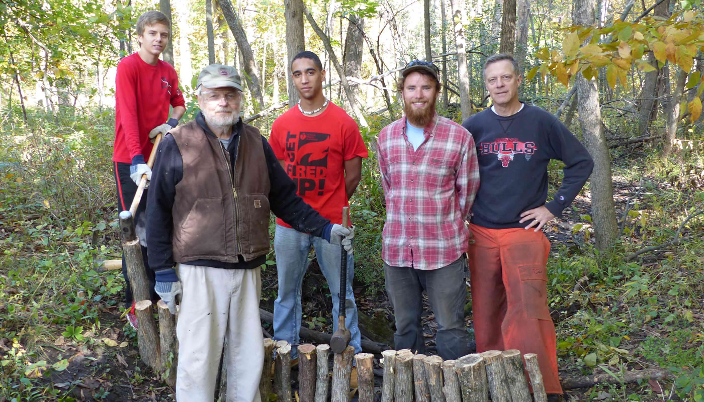 Deer Grove stewards Ron Vargason (second from left) and Pete Jackson (far right) get a hand from other volunteers in building a check-dam to improve the site’s hydrology. Photo by Dale Shields.