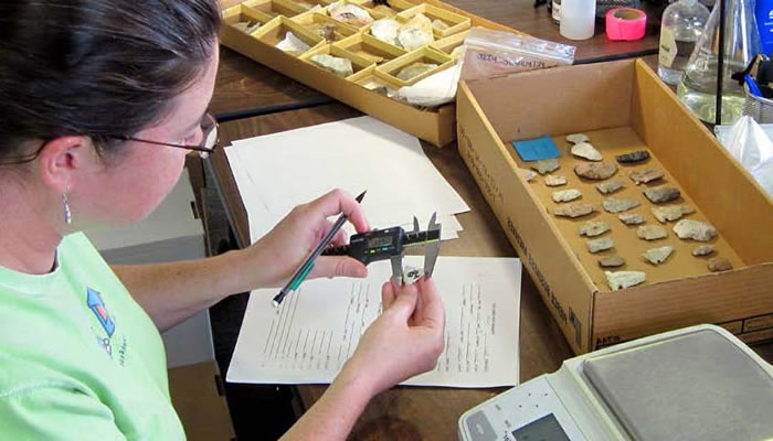 archaeologist measuring an arrowhead