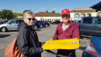 Two volunteers, Ellie Shunas and Lee Witkowski, holding a restoration tool