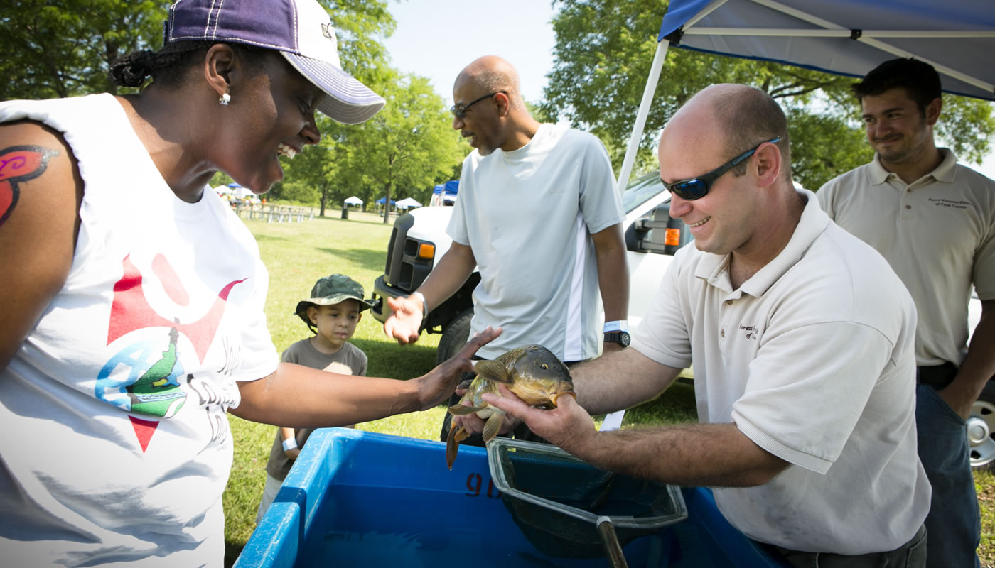 Fisheries biologist Steve Silic shows a visitor a fish at Wampum Lake.