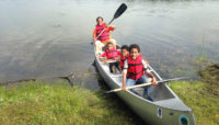 a family returning from a canoe trip on Wampum Lake