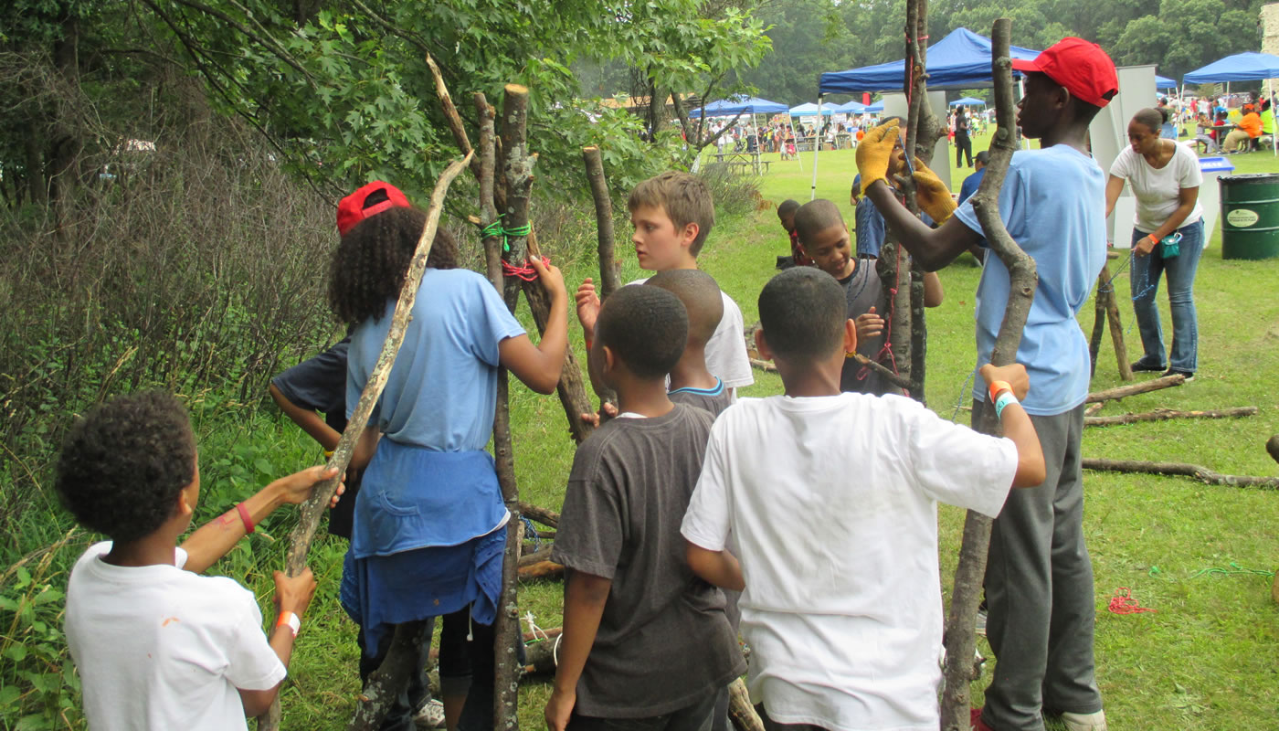 children building a shelter out of tree branches