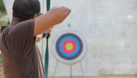 a person taking aim with a bow and arrow