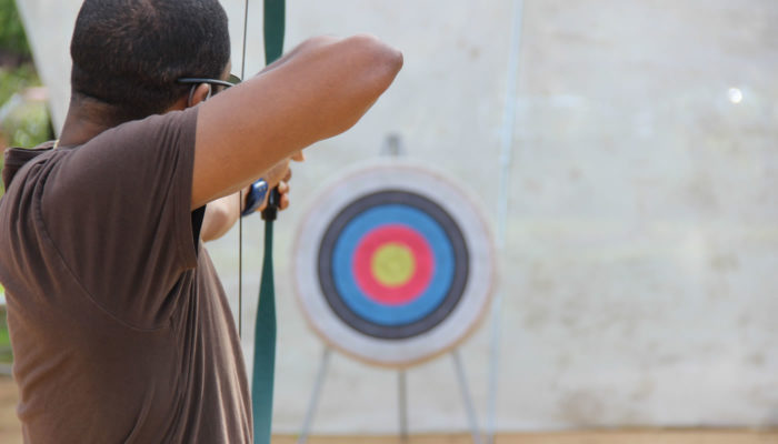 a person taking aim with a bow and arrow