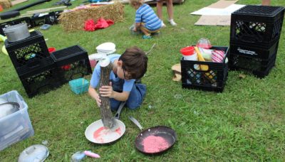 Youth paint using natural materials.