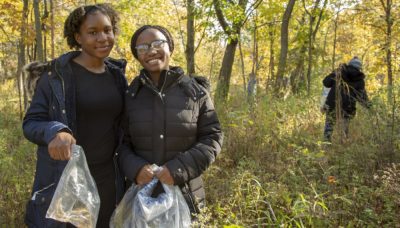 Two youth volunteers collect seed.