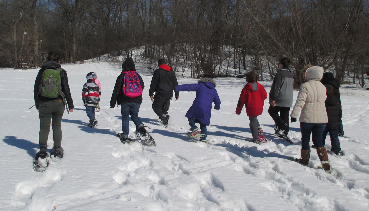 A group of people snowshoeing.