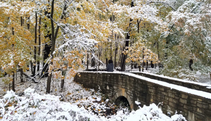 a hiker at Thatcher Woods with snow and fall colors