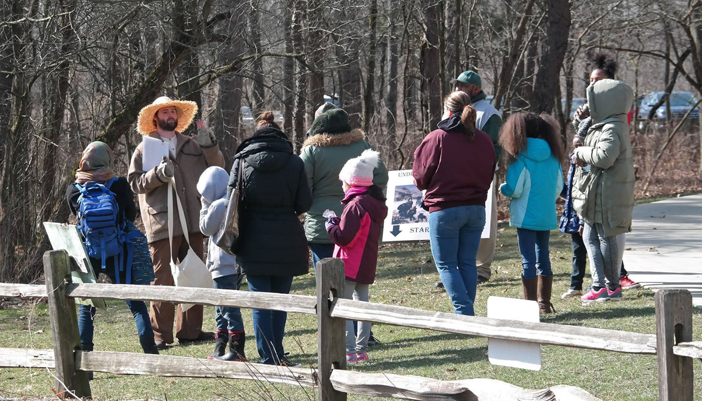 a Forest Preserves staff member leading a group on an Underground Railroad history hike at Sand Ridge Nature Center