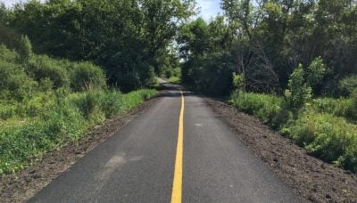 A scene of a newly paved trail spur, enhancing the Poplar Creek Trail System.