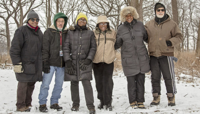 A group of volunteers gathered at Kickapoo Woods, smiling, for a photo