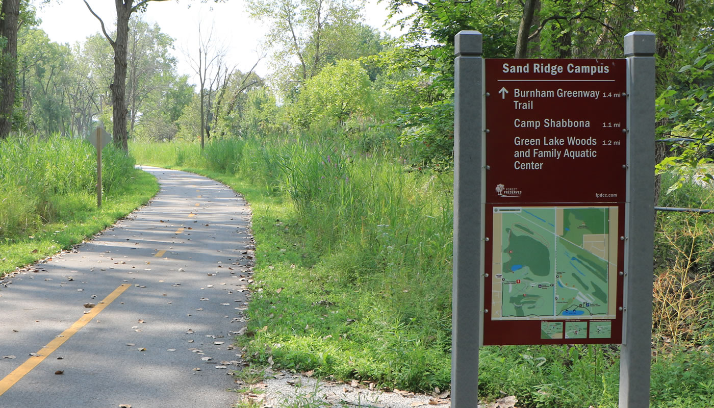 directions sign for Sand Ridge Campus next to a paved trail