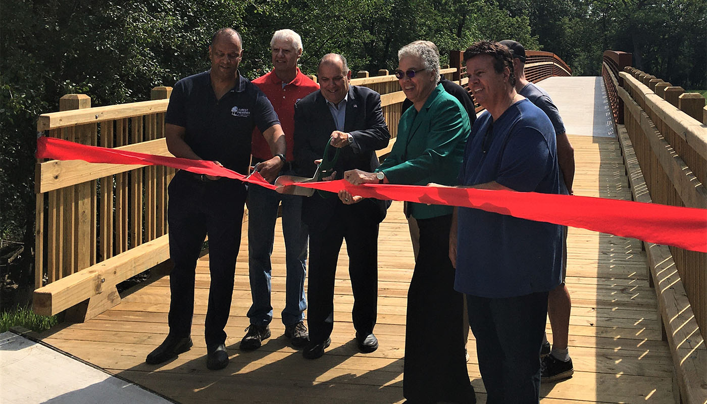 elected officials cutting a ribbon on the Catherine Chevalier Woods Bridge on the Des Plaines River.
