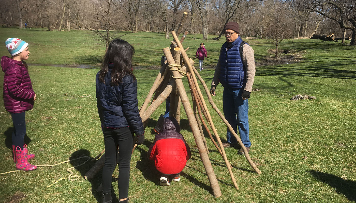 people building a shelter during a wilderness survival event