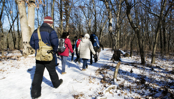 A group hiking in the snow nearby Little Red Schoolhouse Nature Center.