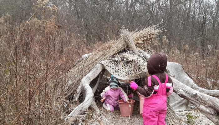 Two children in a nature play area.