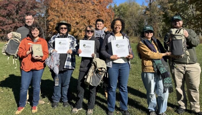 A group of Day Hiking Leadership Training participants hold up their certifications.