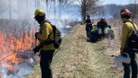 A burn crew conducting a prescribed burn at a forest preserve site.