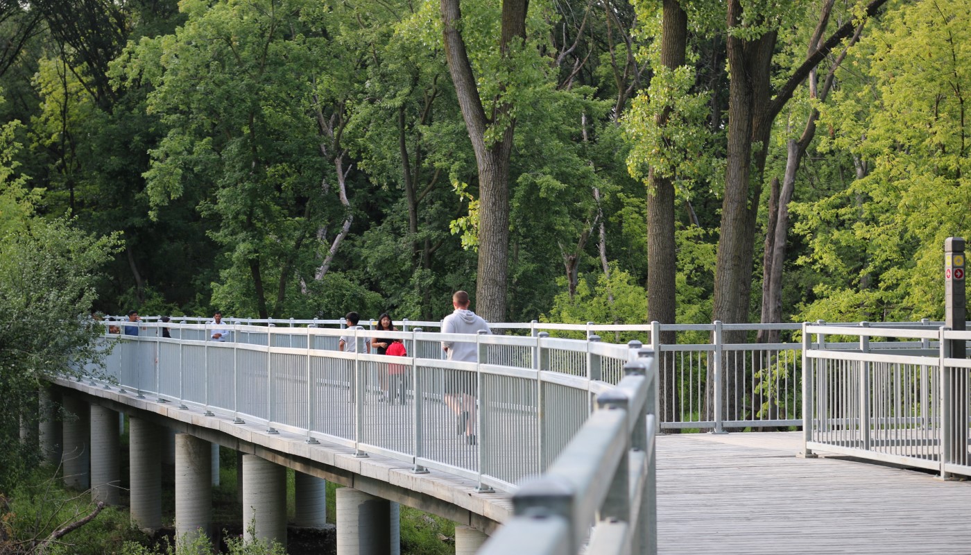 A group of hikers walking along the boardwalk of the Des Plaines River Trail System.