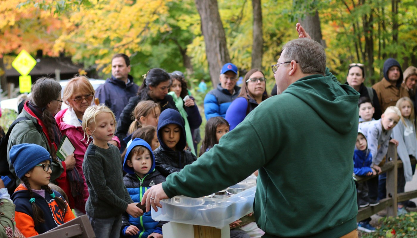 Nature center staff conducting outdoor educational programs for a group of children.