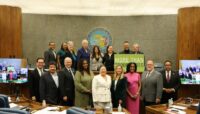 The Board of Commissioners, along with President Preckwinkle and Interim General Superintendent Eileen Figel, pose with a sign reading, "More than 70,000 acres."