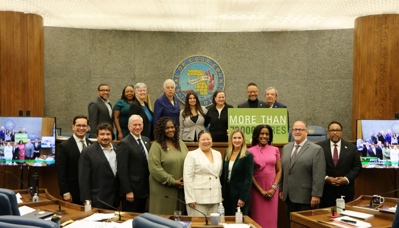 The Board of Commissioners, along with President Preckwinkle and Interim General Superintendent Eileen Figel, pose with a sign reading, "More than 70,000 acres."