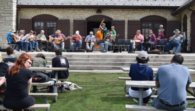 A large group of people at a bluegrass jam.