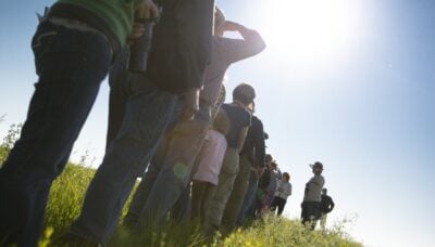 A group of people walking through a prairie.