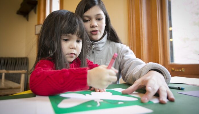 Two children drawing a butterfly at a nature center.