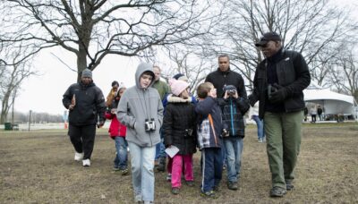 A group of people at a family event in the winter wearing binoculars.