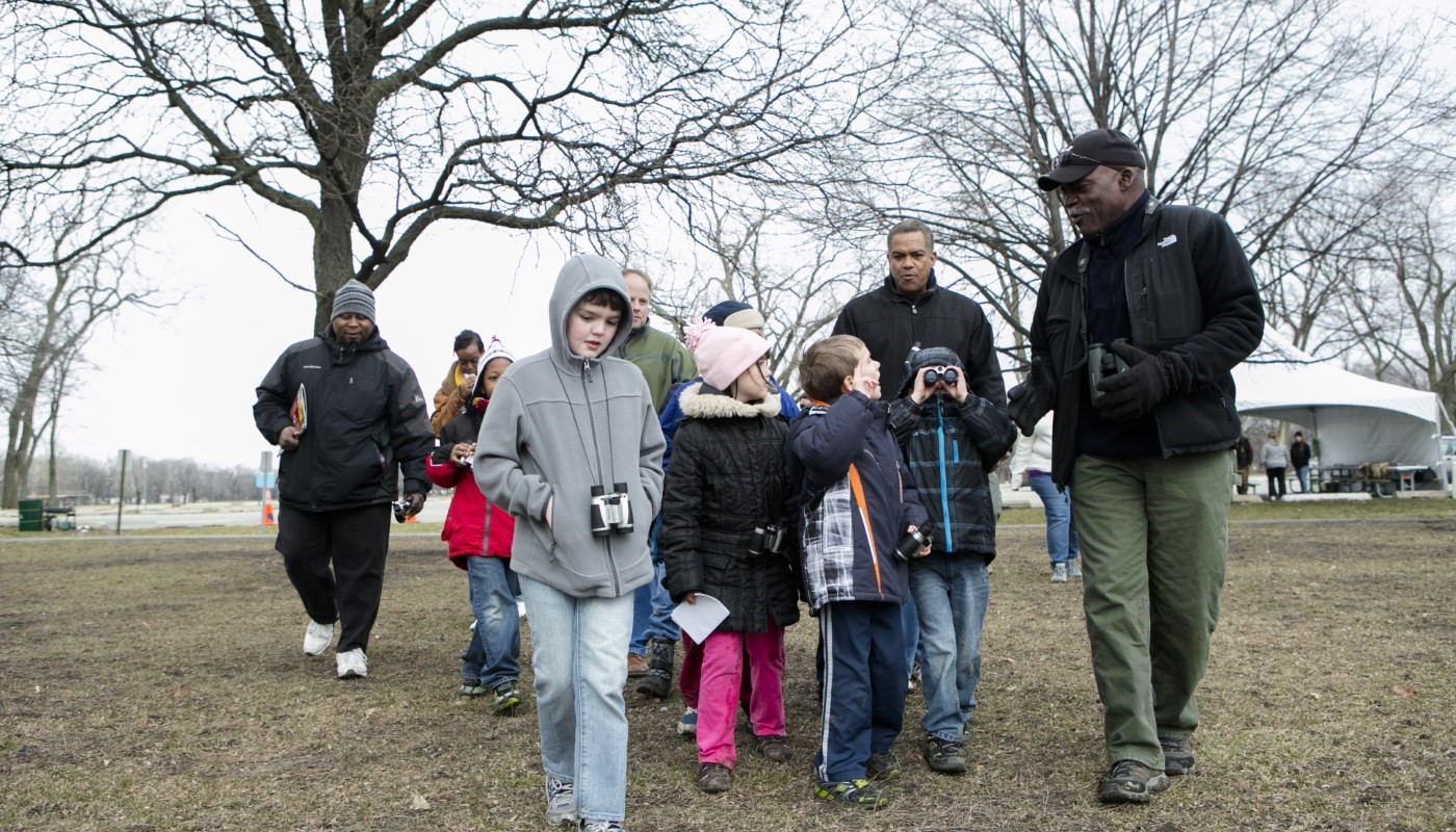 A group of people at a family event in the winter wearing binoculars.