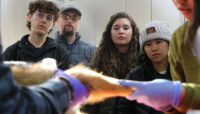 students watch as wildlife staff take vitals of animal