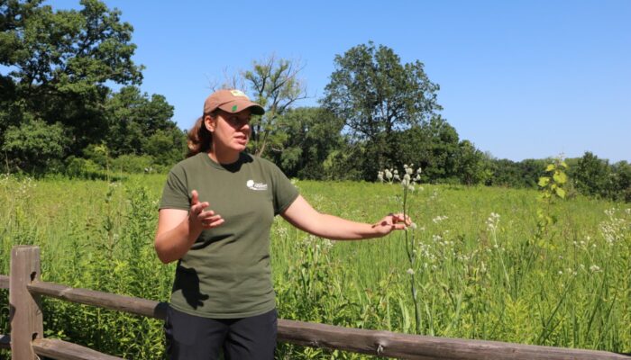 A naturalist in the field presenting about flowers.