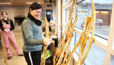 A person viewing an array of walking sticks made from invasive buckthorn.