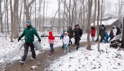 A group of people participating in events at River Trail Nature Center's Maple Syrup Festival.