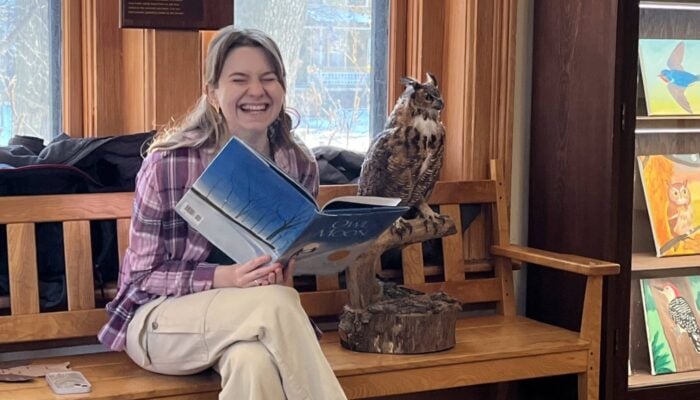 A women reading a book aloud at a nature center event.