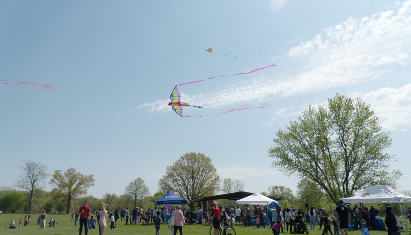 A series of kites soaring through the sky at an outdoor festival.