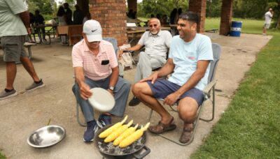 A group of people enjoying their time at an outdoor picnic pavilion.