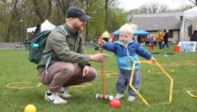 An adult and child engaging in outdoor games at an event.