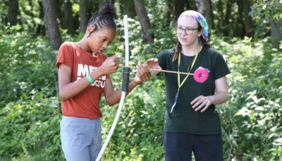 Two people pictured during an outdoor archery event.