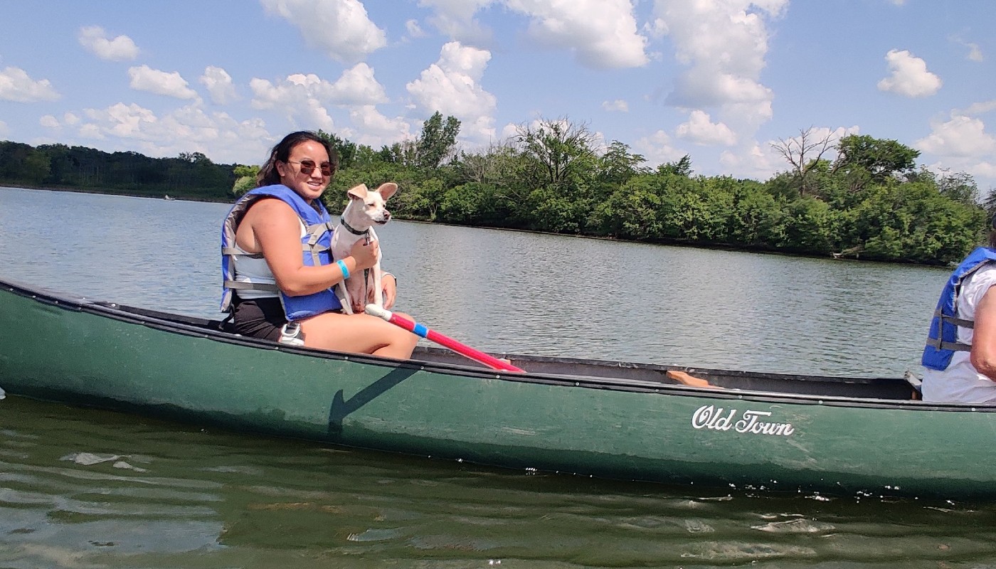A person in a canoe with a dog.